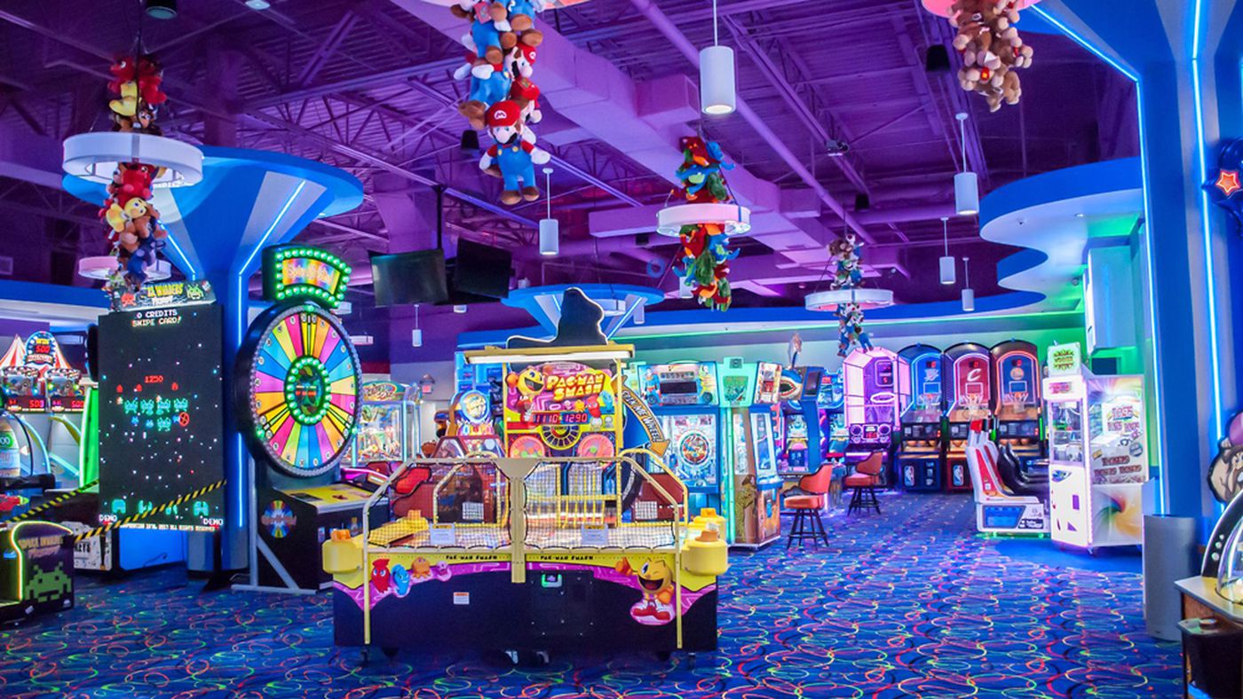 A bright and colourful arcade room with views of arcade games and prizes.